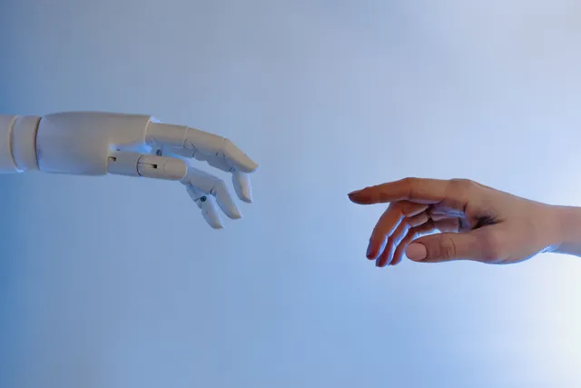 人手与机器人手指尖相触，象征 AI 技术与人力的交汇与张力