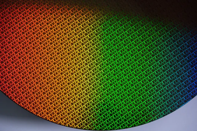 Intel Foundry 的 18A 制程晶圆近景，表面芯片阵列呈现红、橙、绿、蓝色反光。